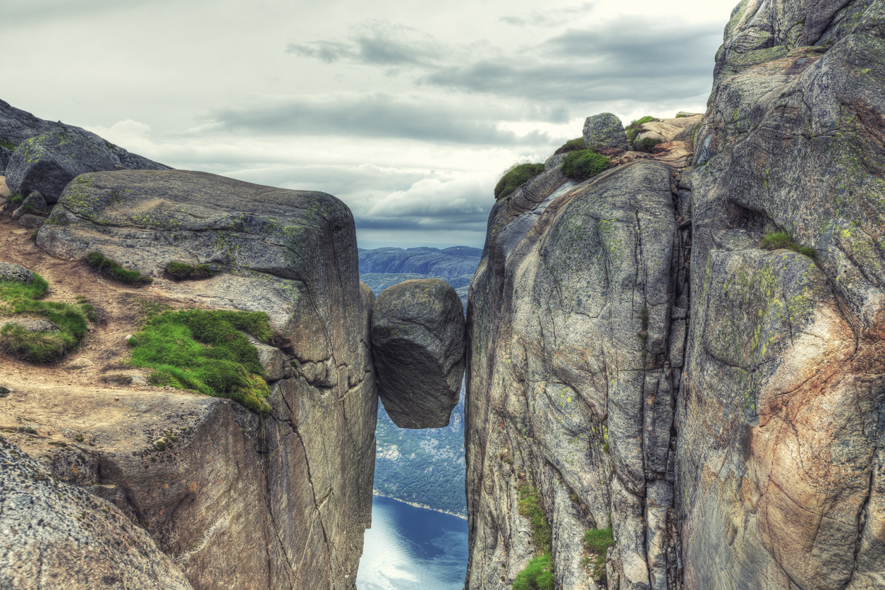 Famous rock wedged and completely stuck between the walls of two steep cliffs in Kjerag Mountains, Norway